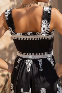 Detail of smocked elastic back and ruffled straps on black and white floral beach dress
