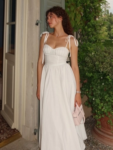 Détail des bretelles nouées et du corsage plissé sur la robe blanche en coton pur
