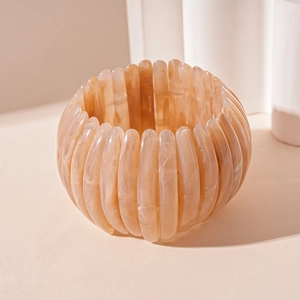 Vue détaillée du bracelet en acrylique marbré ambre avec un design rétro texturé