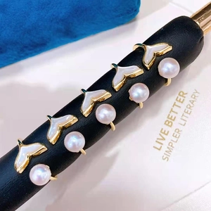 Elegant gold pearl ring with whale tail shell inlay on a professional display