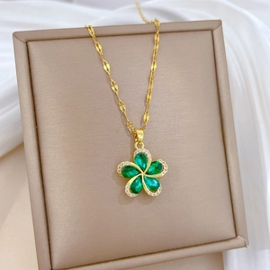 Detail of rotating flower necklace with green stones and crystals on gold chain