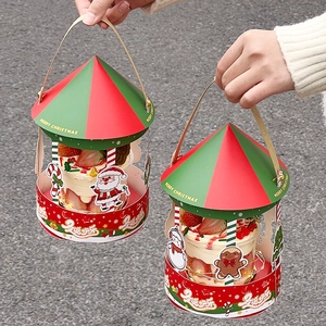 Close-up of Merry Christmas carousel cake boxes with festive red and green hand straps
