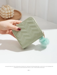 Gros plan du mini portefeuille matelassé vert menthe en cuir PU avec pompon en peluche