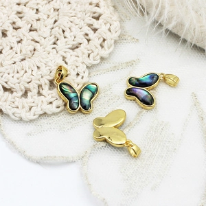 Detailed view of 18k gold plated butterfly pendants with abalone shell inlay on lace