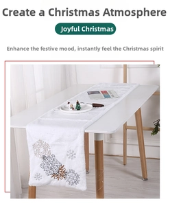 Close-up of white plush Christmas table runner with delicate silver snowflake embroidery