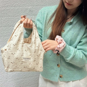 Close-up of beige floral canvas lunch bag with 'SOZAKKA' woven label detail