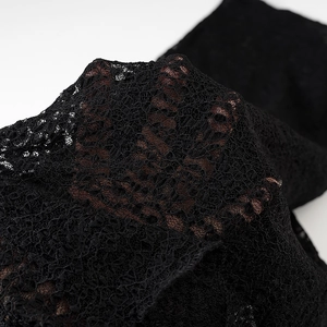 Détail de la texture en dentelle noire et du motif floral de la jupe longue sirène