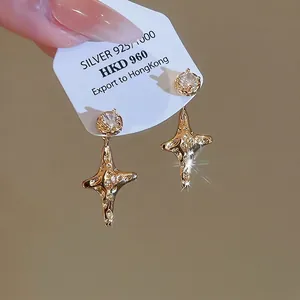 Gold plated 925 silver star earrings with round cubic zirconia and fluid metal texture