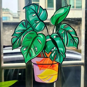Close-up of a Monstera leaf acrylic suncatcher with colorful patterns and metal chain