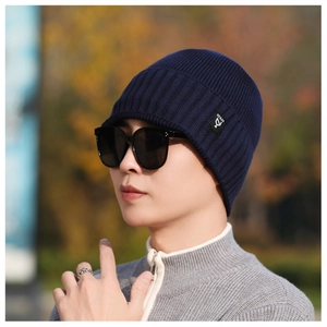 Detail of navy blue ribbed knit beanie featuring a side logo patch and premium texture