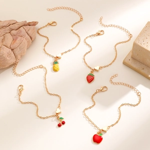 Dettaglio di braccialetti con ciondoli a frutta come ananas fragola e ciliegia