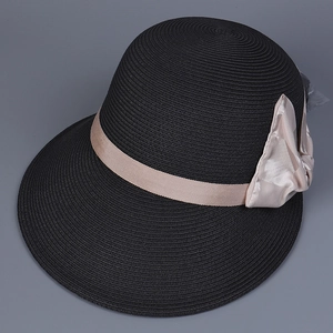 Close-up of fine straw texture and elegant champagne silk bow on black sun hat