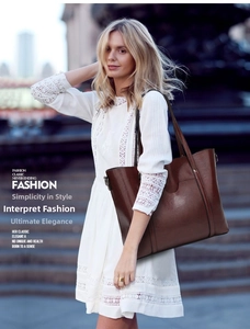 Chic brown leather tote bag worn by a model in a white lace dress on city stairs