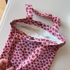 Detail view of pink ruffled floral tote bag featuring a secure metal magnetic clasp closure