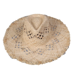 Natural raffia sun hat with wide fringed brim and hollow floral pattern for summer beach vacations