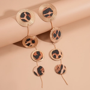 Detailed macro of golden multi-disc drop earrings featuring exotic leopard print textures