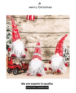 Trois gnomes de Noël festifs avec des bonnets rouges en tricot sur fond de bois