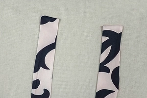 Detailed view of striped halter straps in silky fabric with abstract black patterns