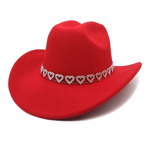 Détail d'un chapeau de cow-boy rouge avec bande argentée et strass en forme de cœur