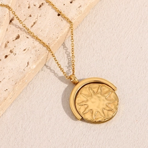 Detail of a rotating sunburst pendant on a gold necklace with 18K plated finish