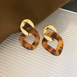 Detailed view of 18K gold plated geometric earrings with amber resin chain link design