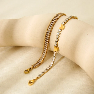 Close-up of gold plated stainless steel bracelets with clear zircons and butterfly charm