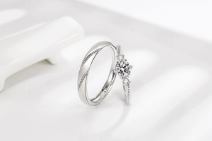 Macro shot of silver couples rings featuring a solitaire diamond and pavé metal bands