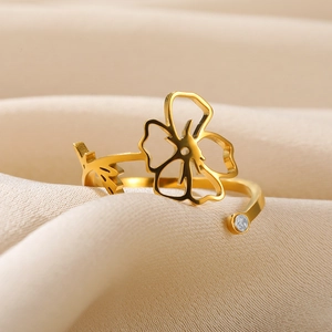 Macro shot of gold hollow flower ring with zircon detail on beige satin fabric