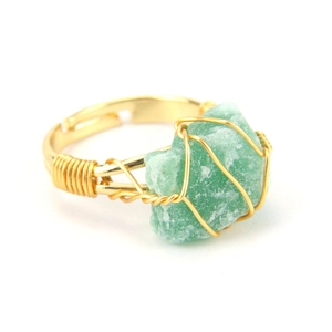 Detail of handcrafted gold wire wrapped ring featuring a natural green raw stone