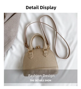 Detail view of beige shell bag with crocodile texture pattern and golden hardware accents