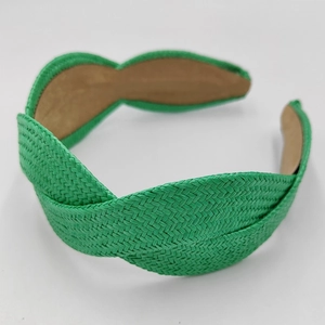 Close-up of bright green straw braided headband with cross-knot detail and brown lining