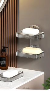 Close-up of wall-mounted transparent soap dish with luxury gold accents in a marble bathroom