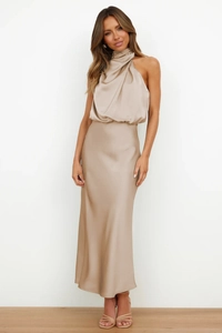 Detail of elegant champagne satin halter dress showing glossy texture and draped neckline