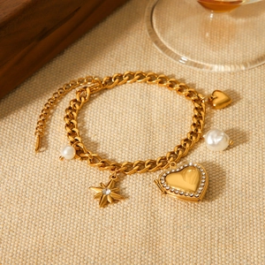 Detail der goldenen Gliederkette mit Diamantherz, Sternanhänger und eleganten Perlen