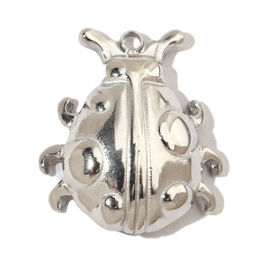Macro detail of a silver ladybug pendant with polished finish and integrated hanging loop