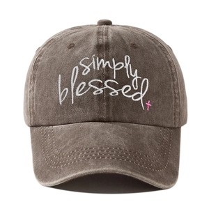 Close-up of Simply Blessed embroidery and pink cross on brown washed cotton baseball cap