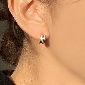 Macro detail of S925 sterling silver hoop earrings with a textured multi-layered design