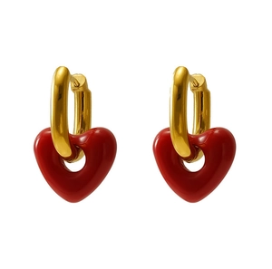 Detail of gold-plated hoop earrings featuring glossy red enamel heart pendants