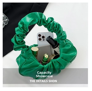 Detail view of grass green pleated cloud handbag showing interior space for phone and makeup