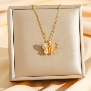 Collier papillon doré de luxe avec zircons bleus et violets sur fond de satin