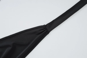 Detail view of stitched elastic straps on black V-neck top with smooth stretch fabric