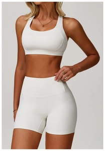 Detail view of seamless white high-waist fitness shorts and matching sports bra set