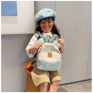 Kids backpack detail with green checkerboard pattern, round ears and Sunday leather patch
