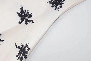 Gros plan sur l'imprimé floral crème avec des détails de silhouettes de fleurs