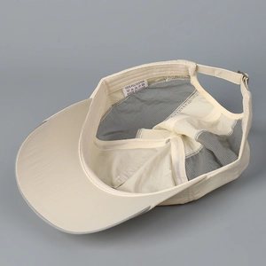 Inside view of beige quick-dry baseball cap showing breathable mesh and polyester tag