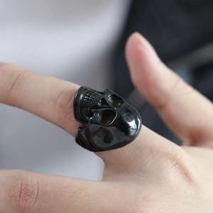 Macro di un anello a teschio nero stile punk con dettagli gotici in metallo lucido