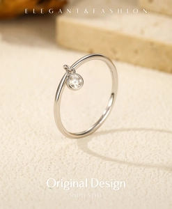 Detail view of S925 sterling silver ring with a minimalist dangling round moissanite pendant