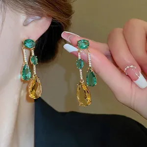 Élégantes boucles d'oreilles dorées avec des pierres de zircon jaune et vert vif