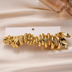 Detail of 20-piece gold irregular geometric rings displayed on beige silk fabric