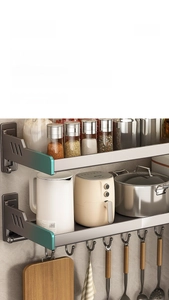Macro detail of gunmetal kitchen rack with green trim showing sturdy wall mount and hooks